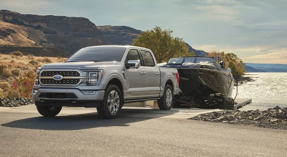 A grey 2024 Ford F-150 towing a boat.
