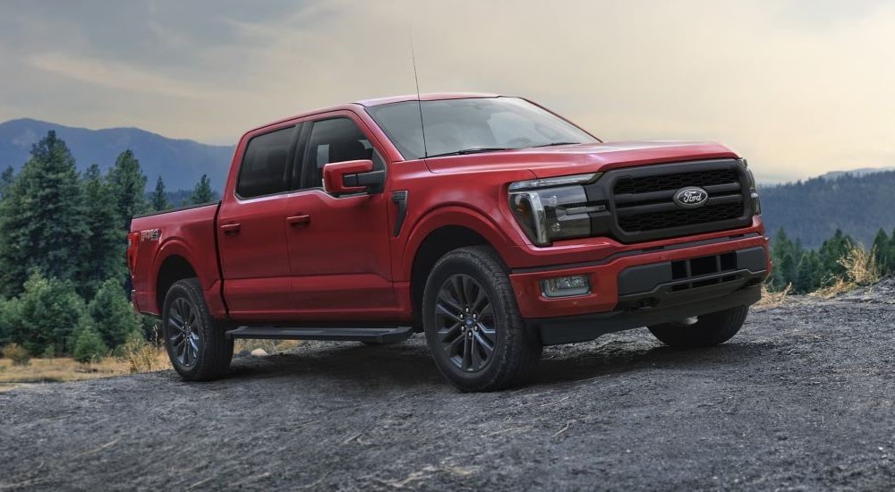 A red 2024 Ford F-150 Lariat parked off-road.