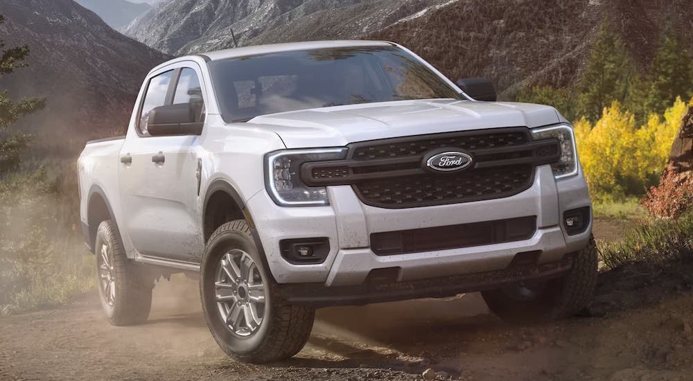 A white 2024 Ford Ranger driving on a dusty trail.