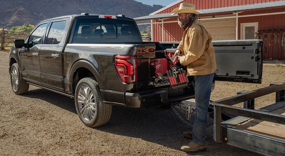 A farmer taking tools out of the bed of a 2024 Ford F-150 King Ranch.