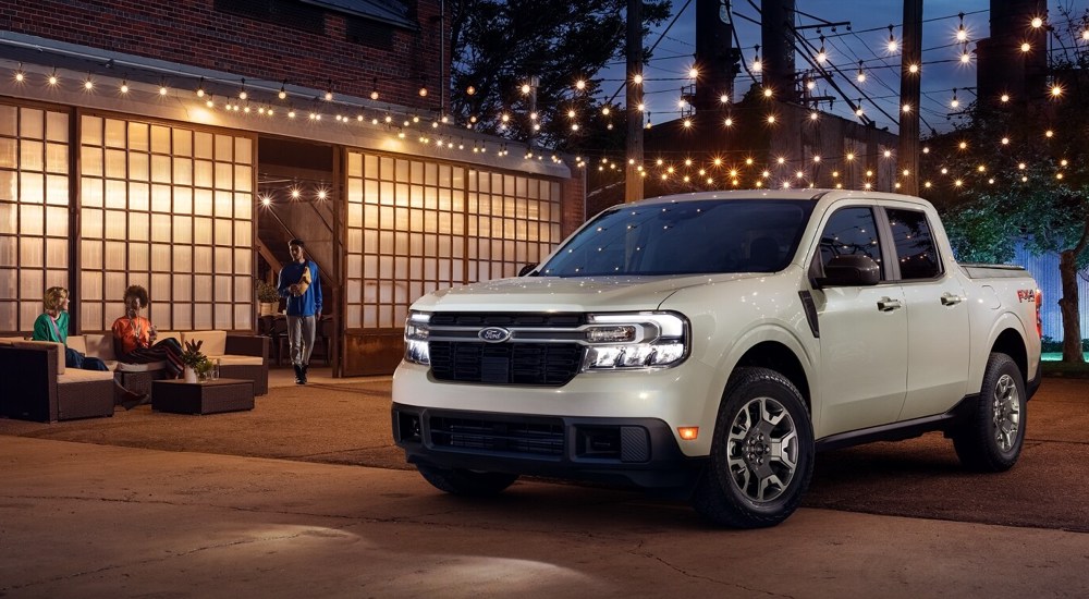 A white 2022 Ford Maverick LARIAT parked under lights at night.