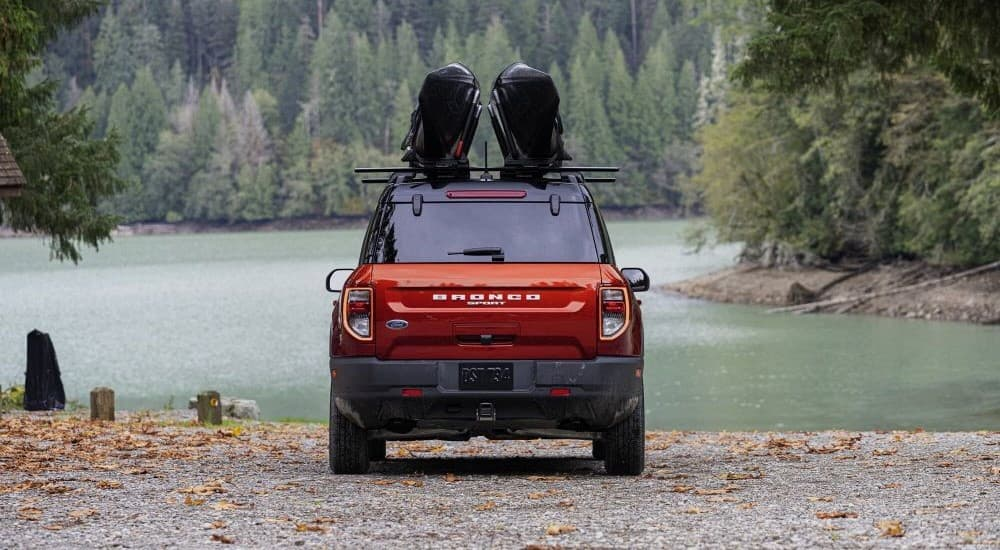 A red 2023 Ford Bronco Sport parked near a lake.