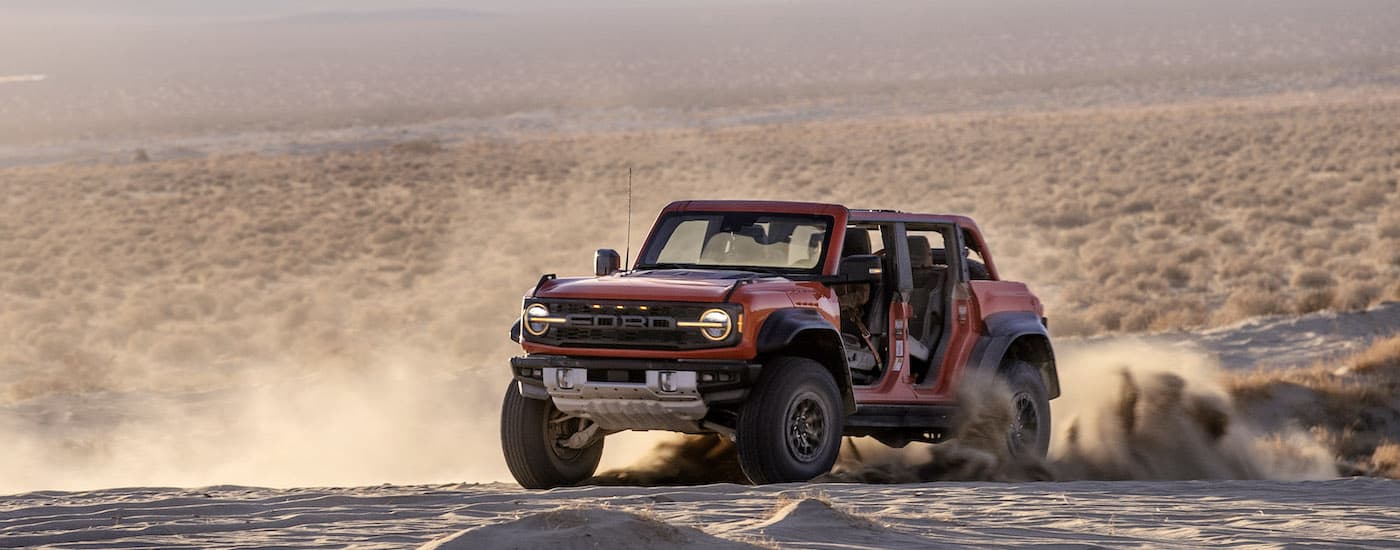 A red 2022 Ford Bronco Raptor is shown from the front at an angle after leaving a Ford dealer.