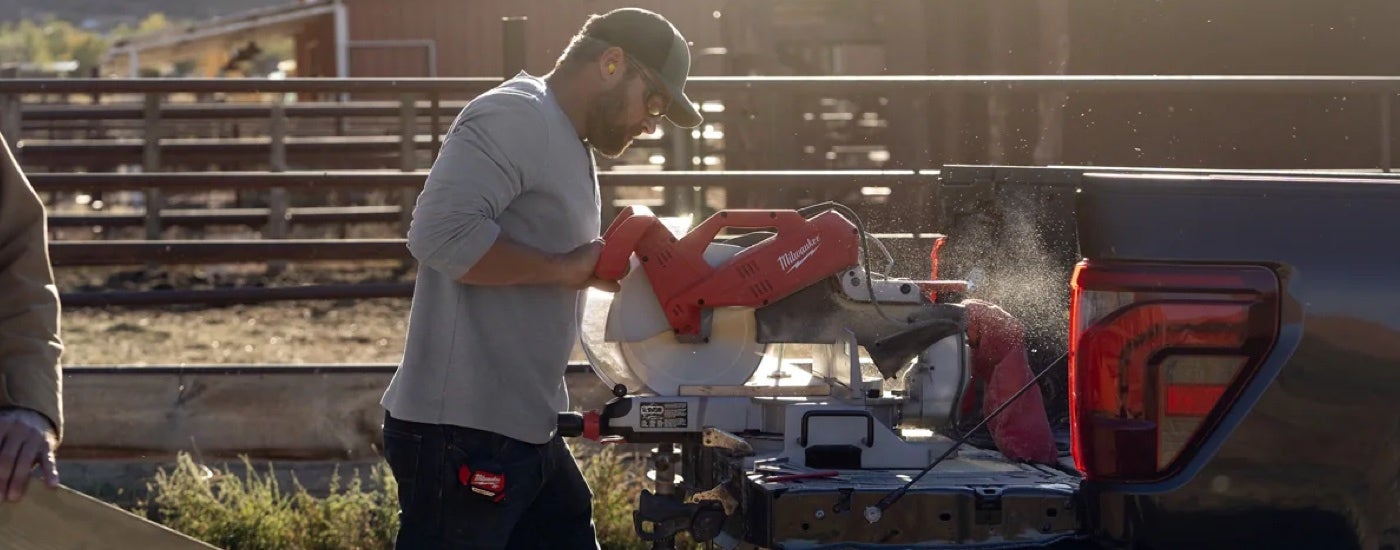 A rancher using a power saw on the tailgate of a 2024 Ford F-150.