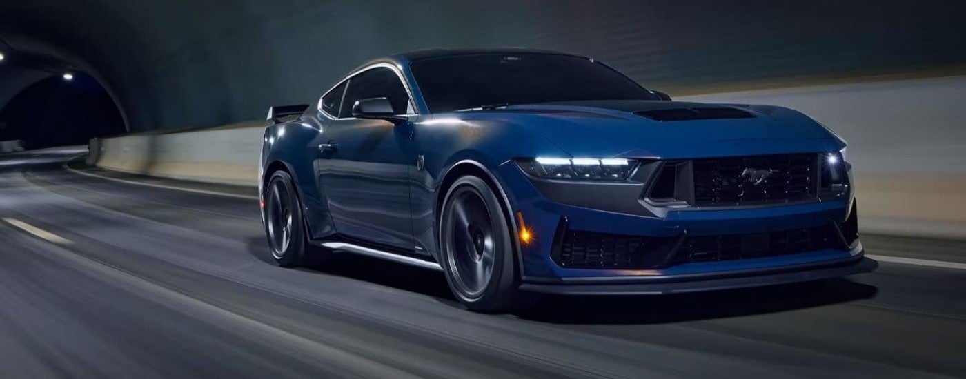 A blue 2024 Ford Mustang Dark Horse driving through a tunnel from a Ford dealer near Peoria.